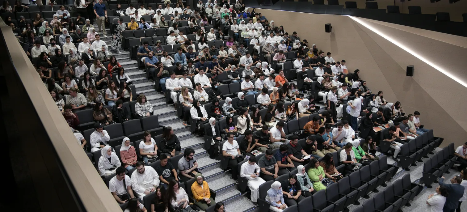 Students at AUK attentively listening to a presentation in the university's seminar hall, emphasizing academic excellence.
