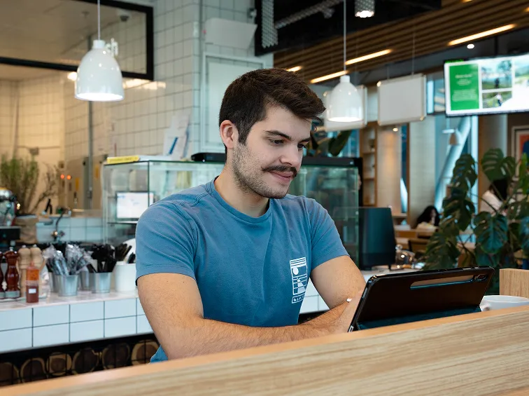 A dedicated AUK student engrossed in studying, seated in the university cafeteria.