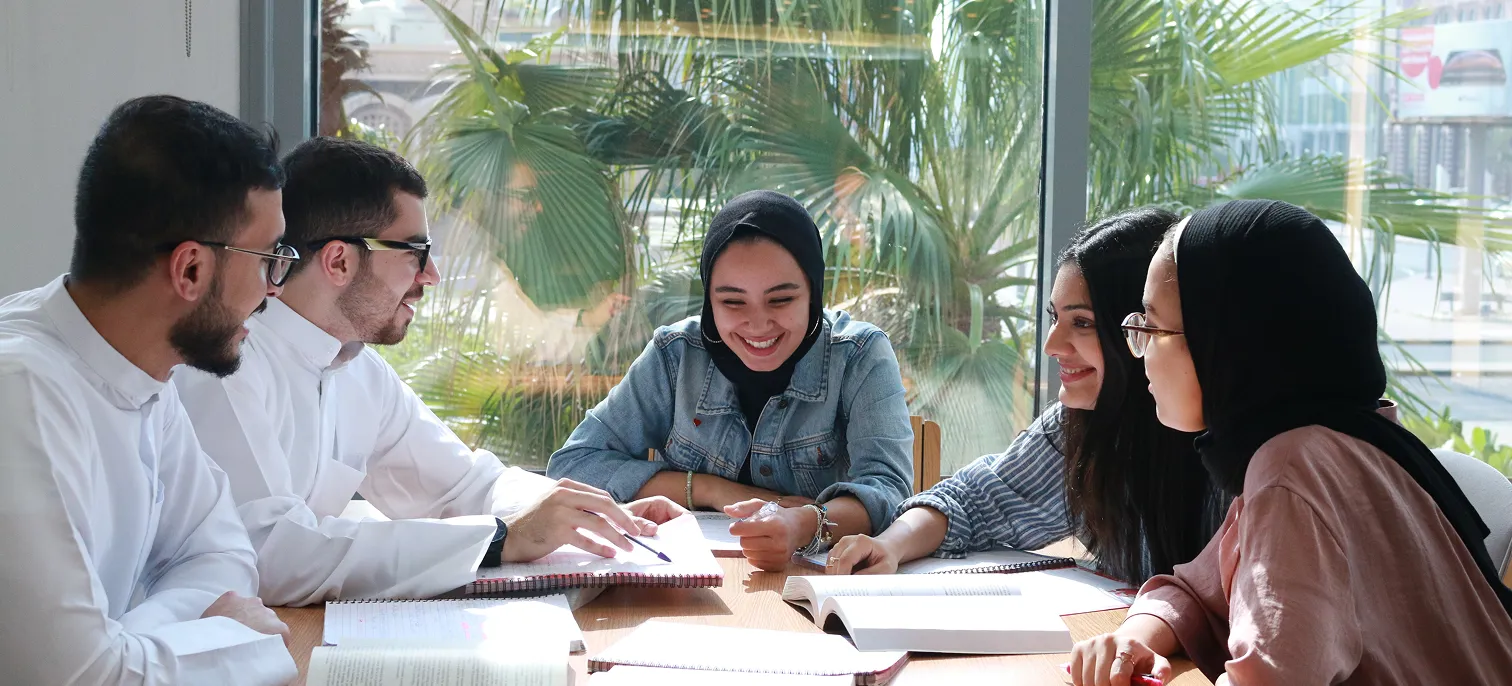 A group of AUK students working together on a group study session, showcasing teamwork and academic focus.