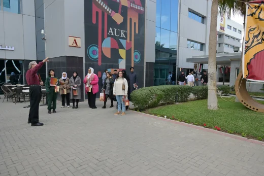 A professor leading a guided campus tour at AUK, showcasing modern facilities, amenities, and inspiring surroundings.