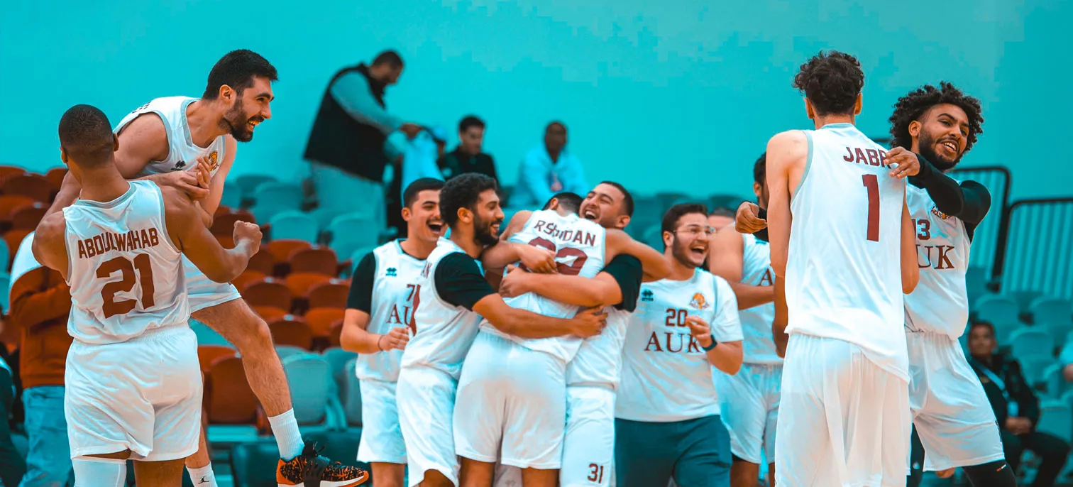 A group of AUK basketball players celebrating a victory.