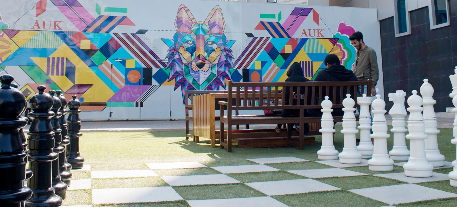 A creative view of the AUK campus featuring a chessboard-inspired design.