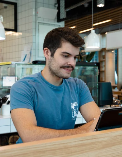 A dedicated AUK student engrossed in studying, seated in the university cafeteria.